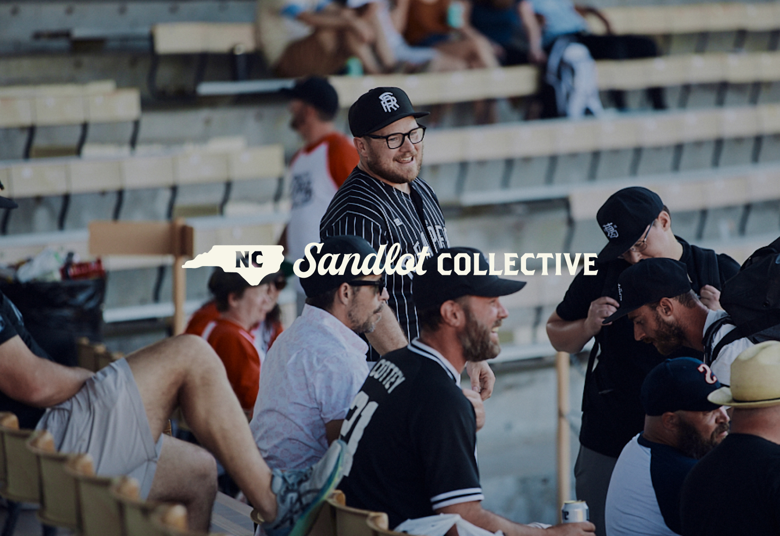 Logo overtop photo of players and fans in the stands | Carolina Sandlot Collective